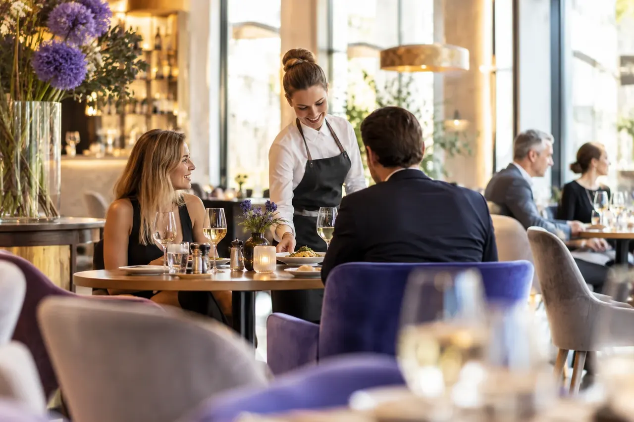 Restaurant mit gedeckten Tischen und G&auml;sten